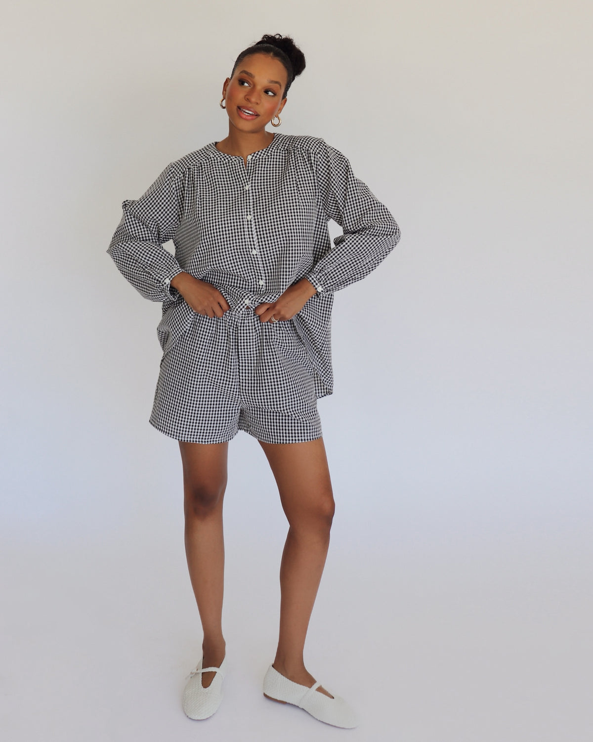 Woman wearing a black and white checkered outfit on a plain background