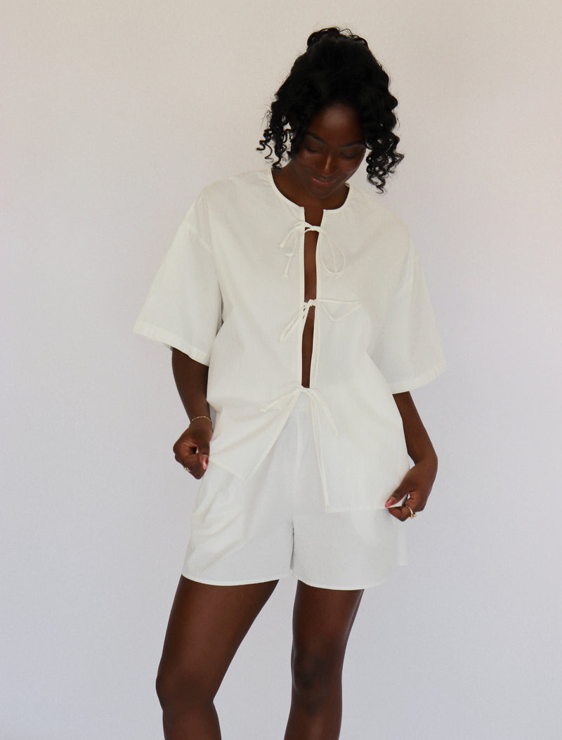 Person wearing a white outfit set with a plain background