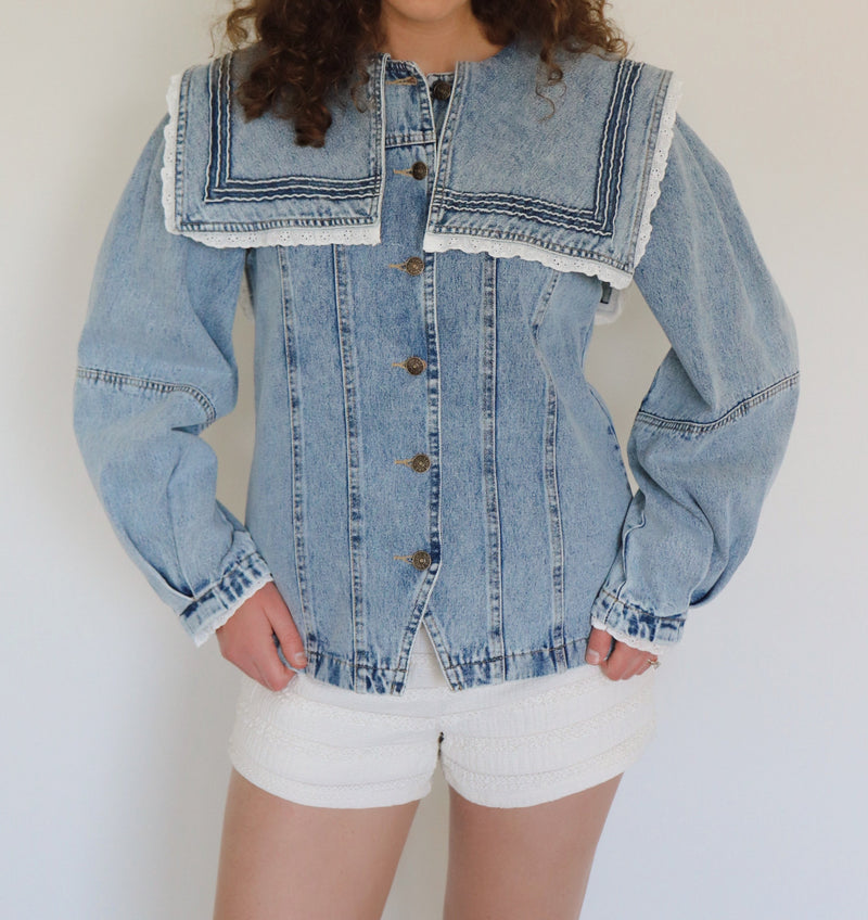 woman wearing a detailed denim jacket with white shorts 
