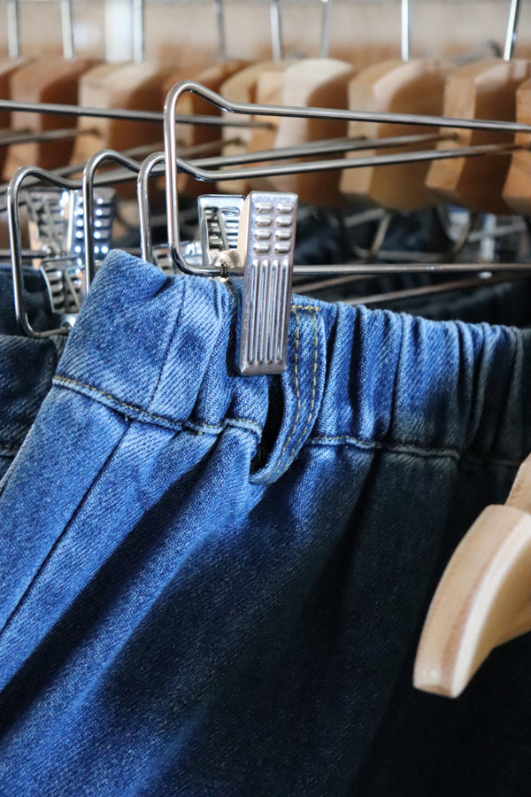 Blue jean shorts hanging on a rack