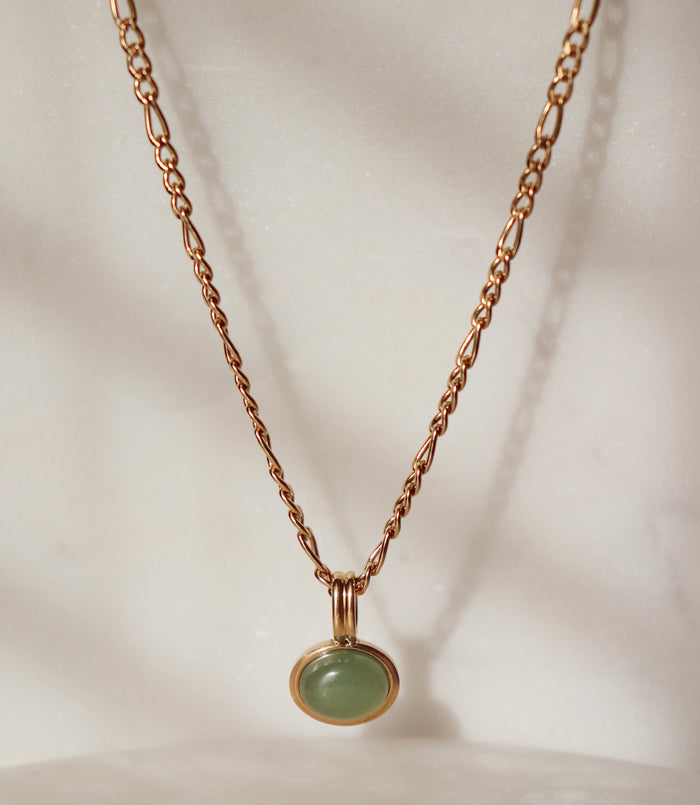 Necklace with a green pendant on a soft white background