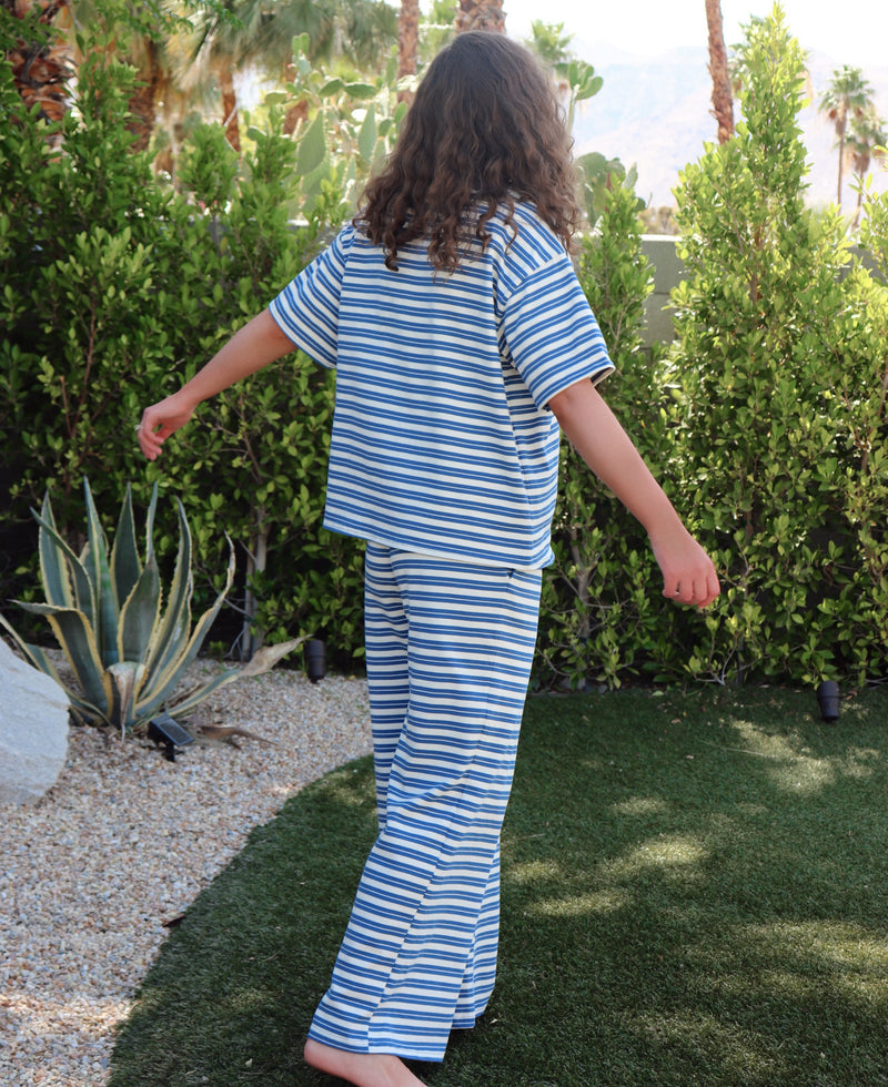 woman wearing blue and white striped set in an outdoor setting