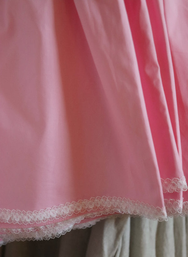Close-up of a pink fabric with lace trim