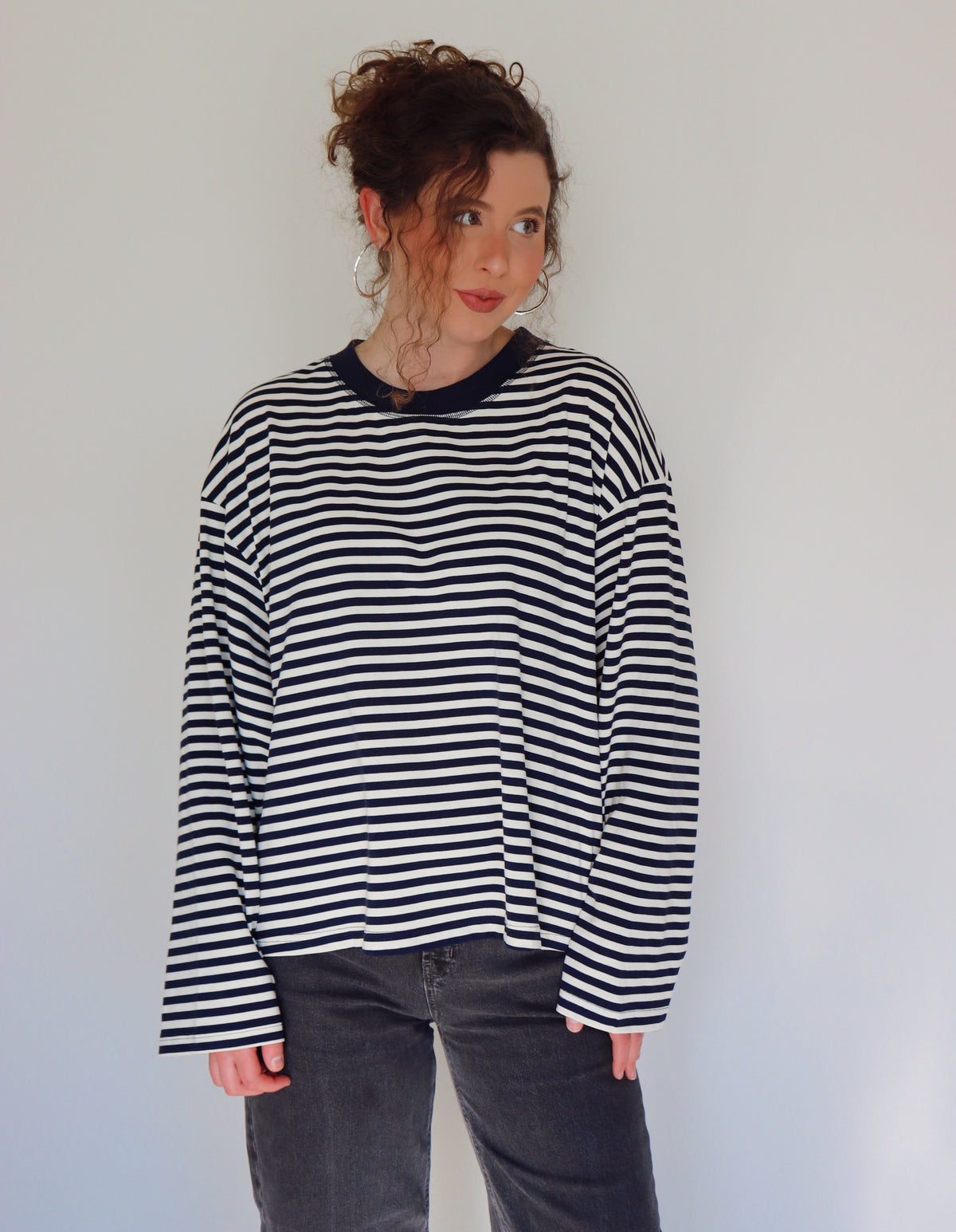 Person wearing a navy and white striped top against a plain background.