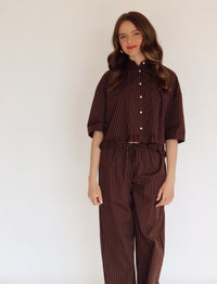 Person wearing a brown set with white stripes.