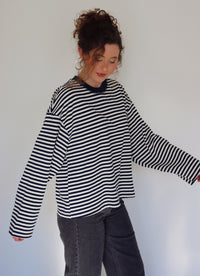 Person wearing a navy and white striped top against a plain background.