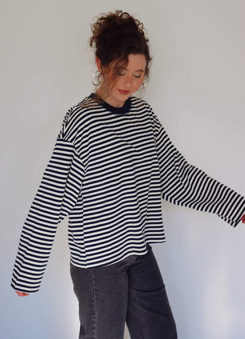 Person wearing a navy and white striped top against a plain background.
