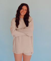 Person wearing light gray striped lounge set in front of a blue wall.