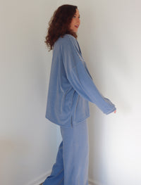 Woman wearing a blue outfit against a white wall