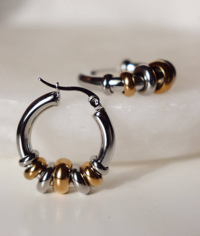 Silver and gold hoop earrings on a white background