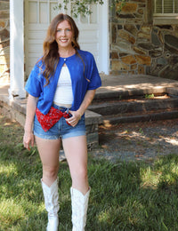 Woman in blue cardigan in an outside setting