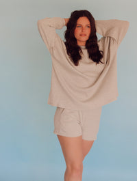 Person wearing light gray striped lounge set in front of a blue wall.