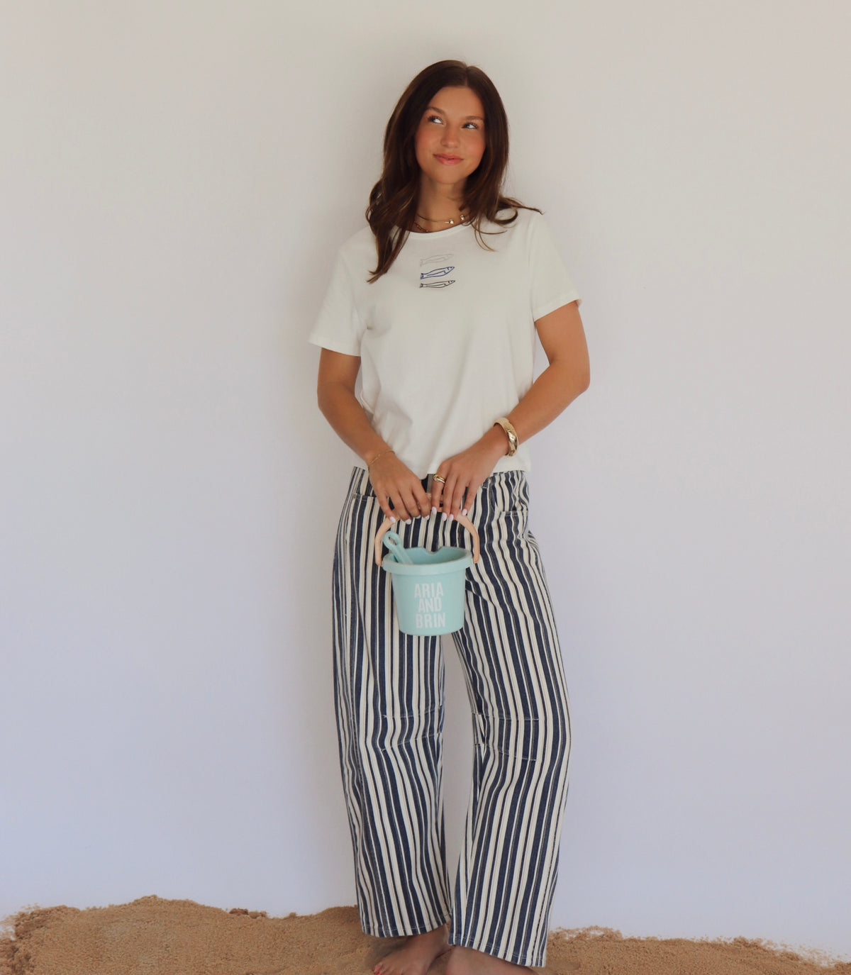 Woman holding a small blue bucket against a plain white background