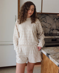 woman wearing taupe and white striped set in a kitchen setting