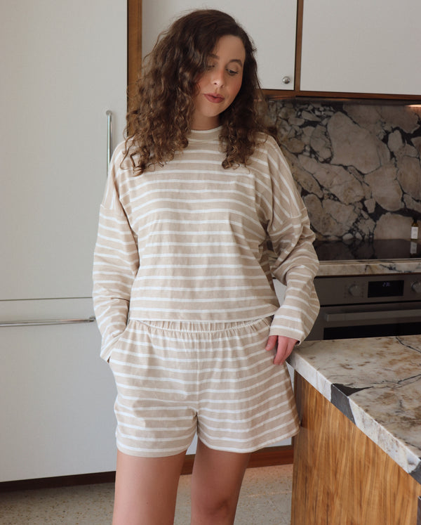 woman wearing taupe and white striped set in a kitchen setting