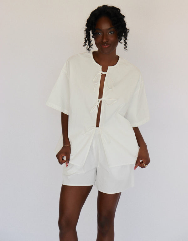 Person wearing a white outfit set with a plain background