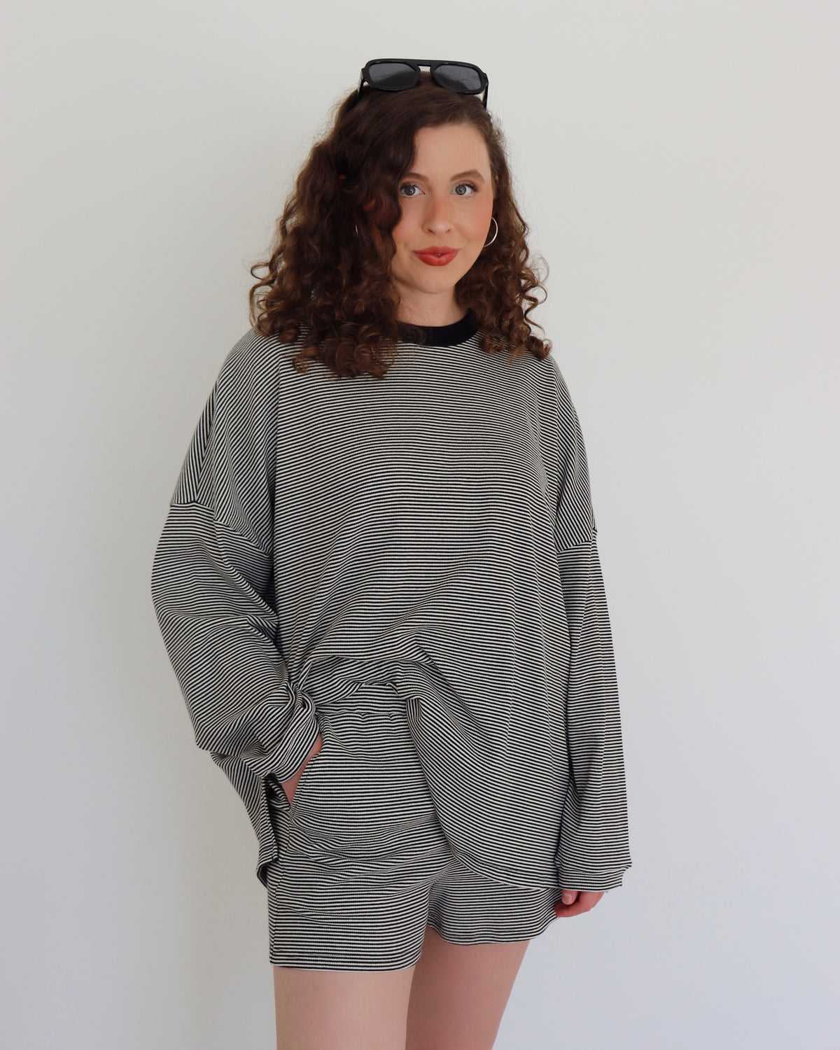 Woman wearing a black striped set against a white background