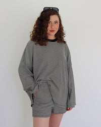 Woman wearing a black striped set against a white background