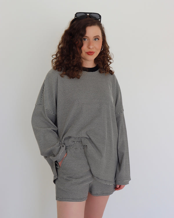 Woman wearing a black striped set against a white background