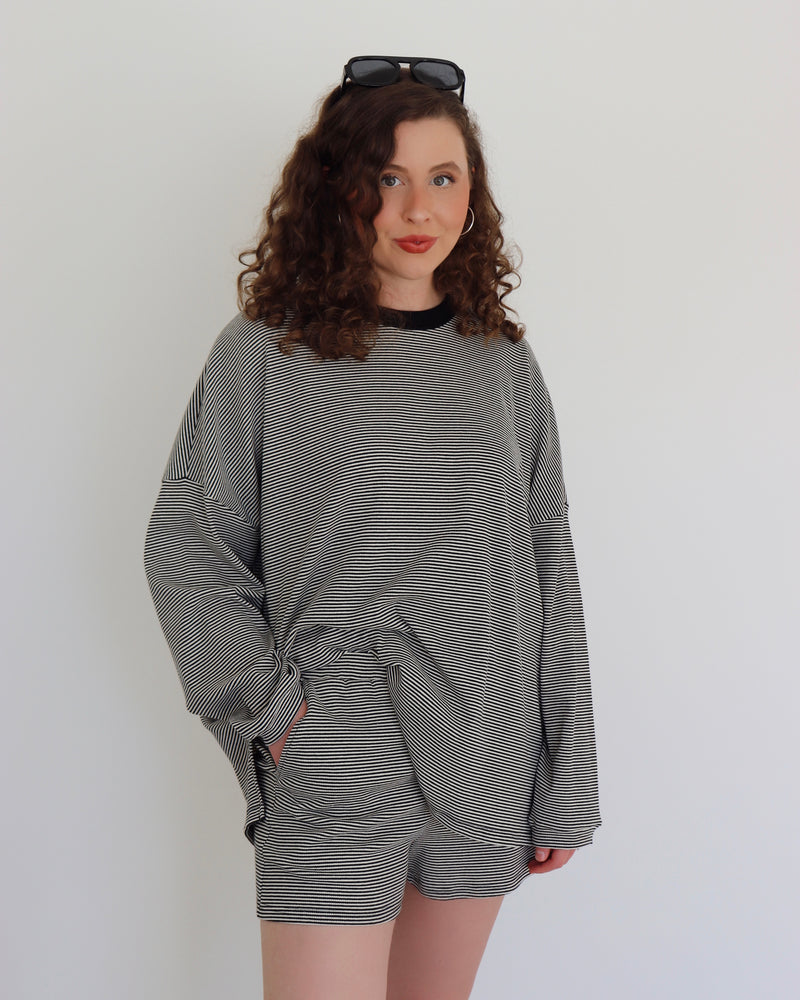 Woman wearing a black striped set against a white background