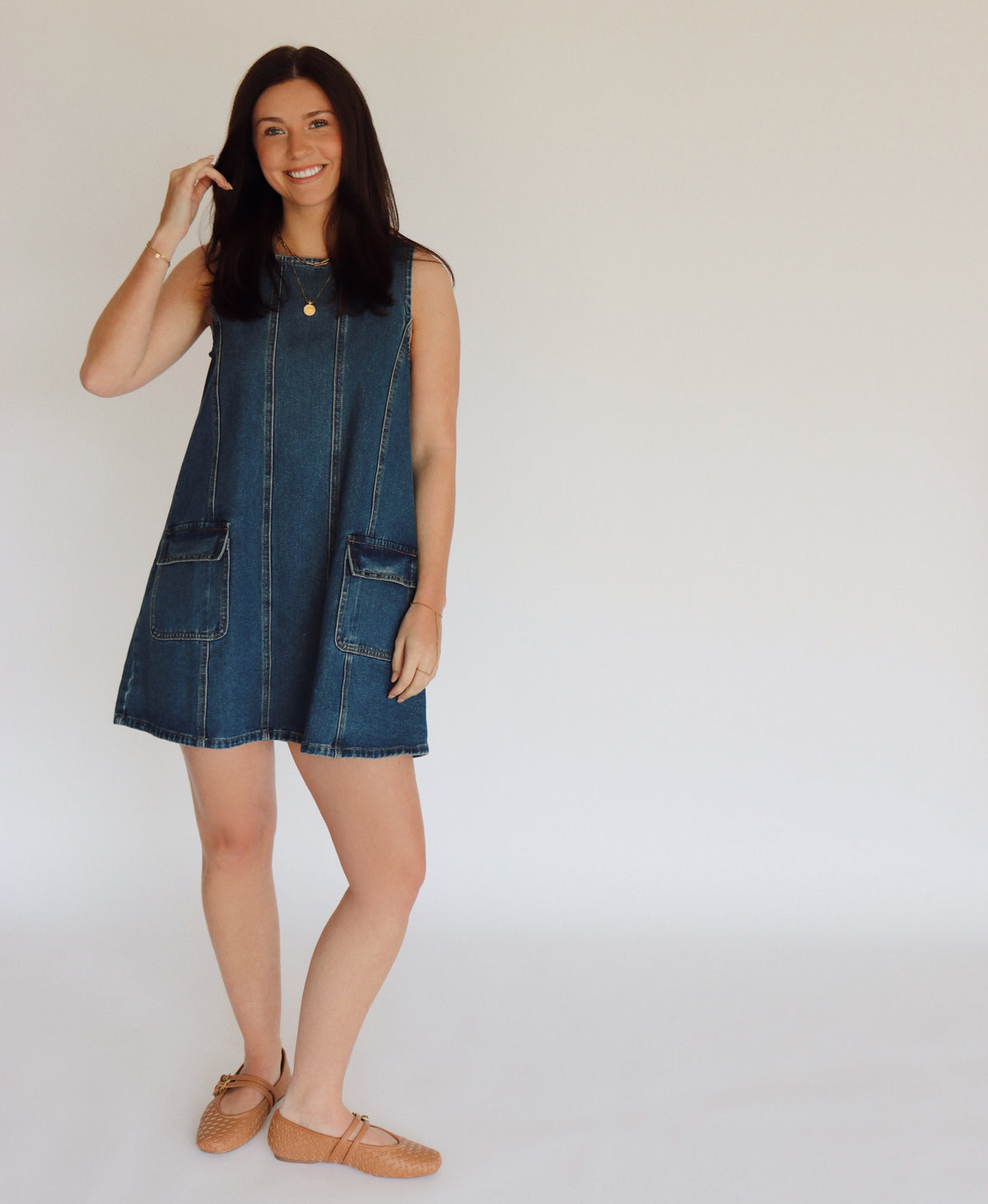 Woman wearing a denim dress against a plain background