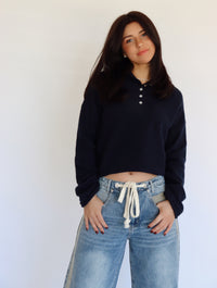 Woman wearing a blue top and blue jeans against a white background