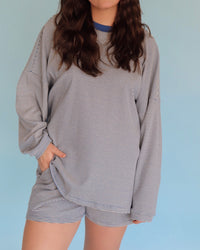 Person wearing a blue striped loungewear set against a light blue background
