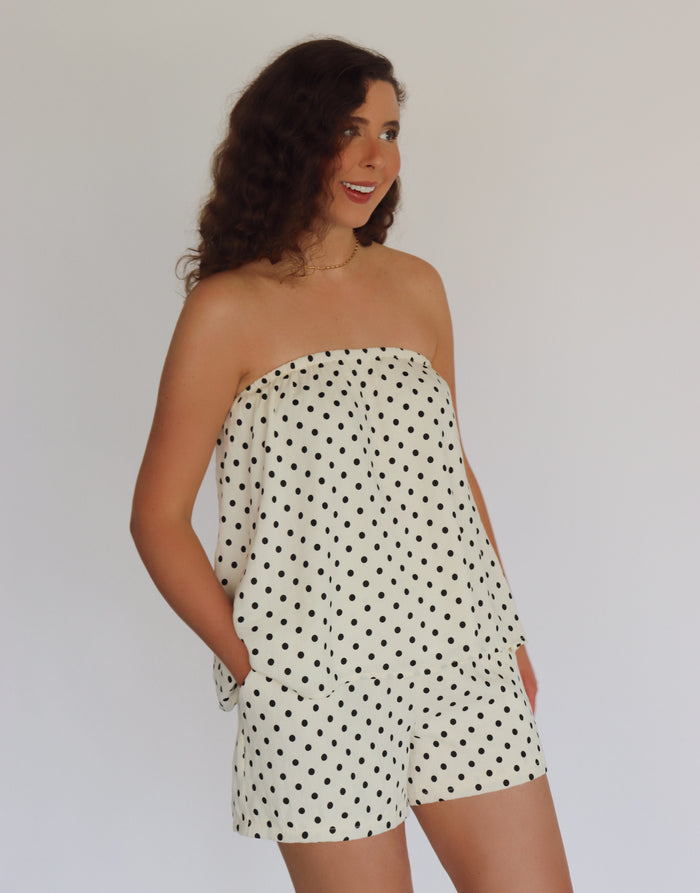 woman wearing a polka dot set against a plain background