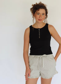 woman wearing a black tank top and striped shorts