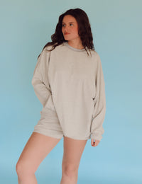 Person wearing light gray striped lounge set in front of a blue wall.