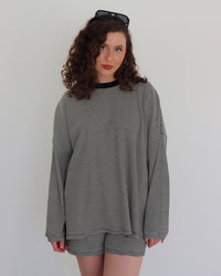 Woman wearing a black striped top and shorts against a white background