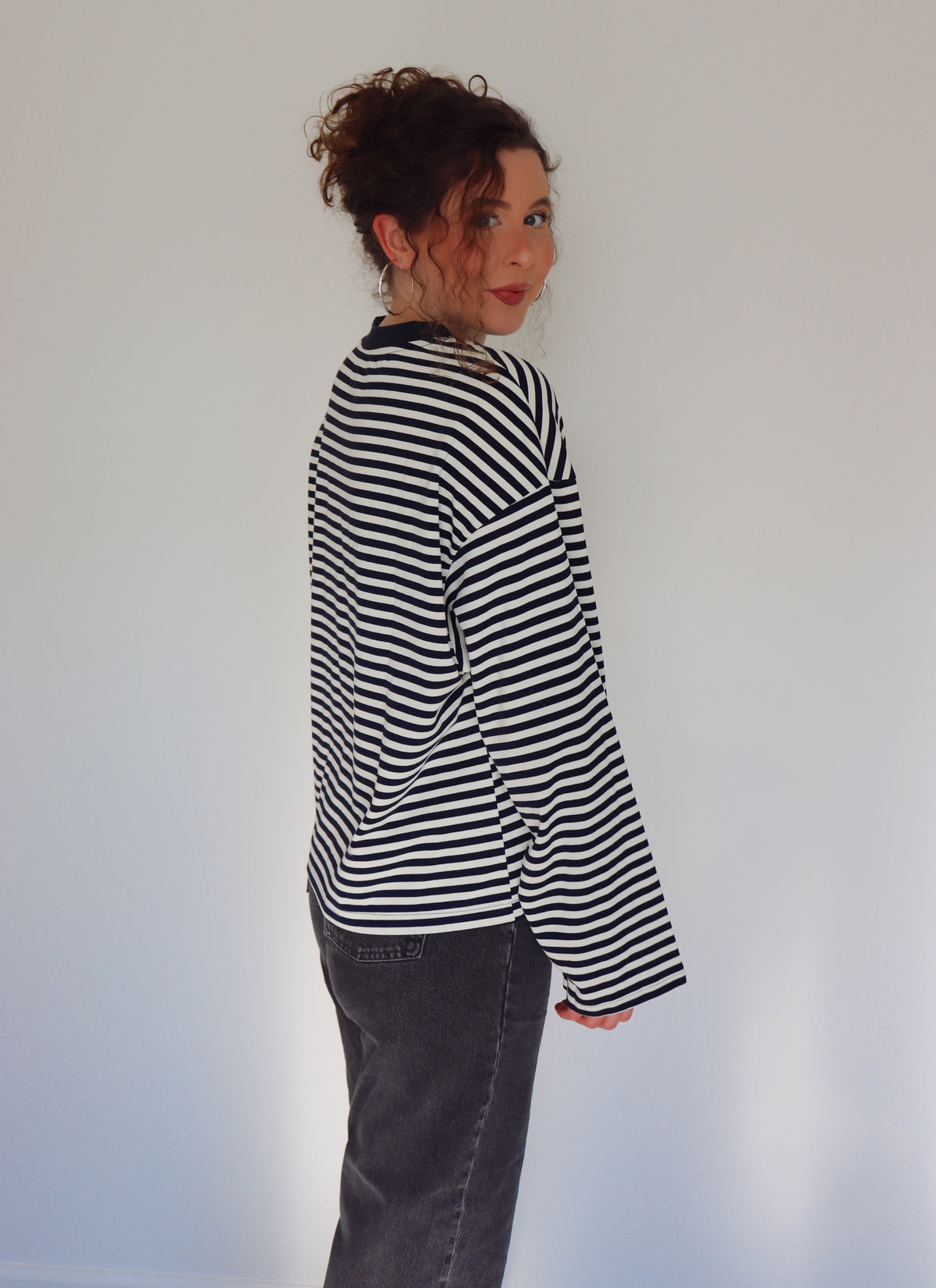 Person wearing a navy and white striped top against a plain background.