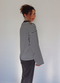 Person wearing a navy and white striped top against a plain background.