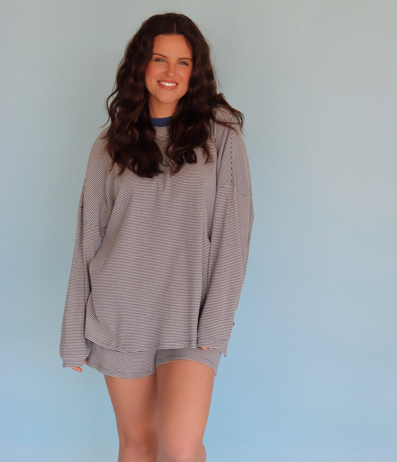 Person wearing a blue striped loungewear set against a light blue background