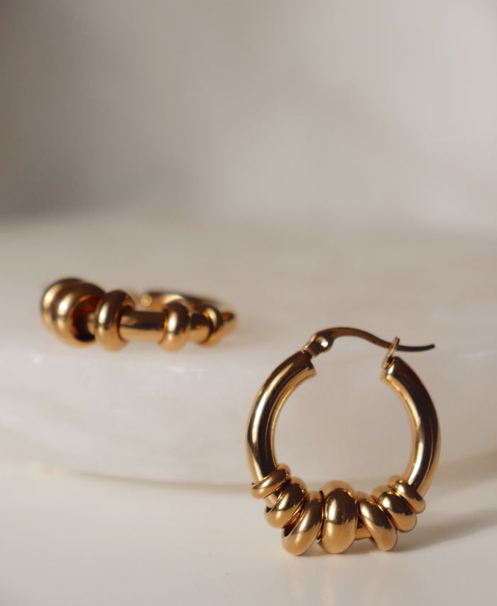 Gold hoop earrings on a light background