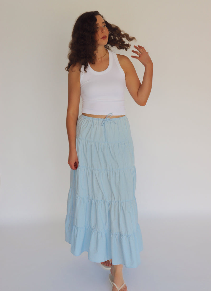 woman wearing a light blue maxi skirt and white tank top