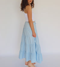 woman wearing a light blue maxi skirt and white tank top