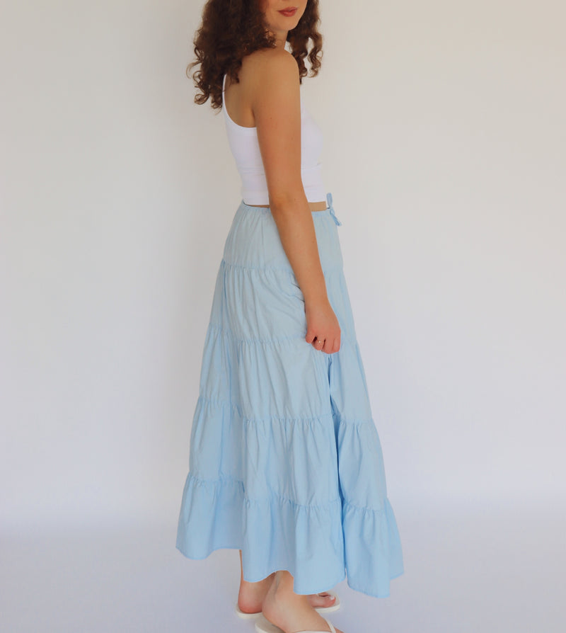 woman wearing a light blue maxi skirt and white tank top