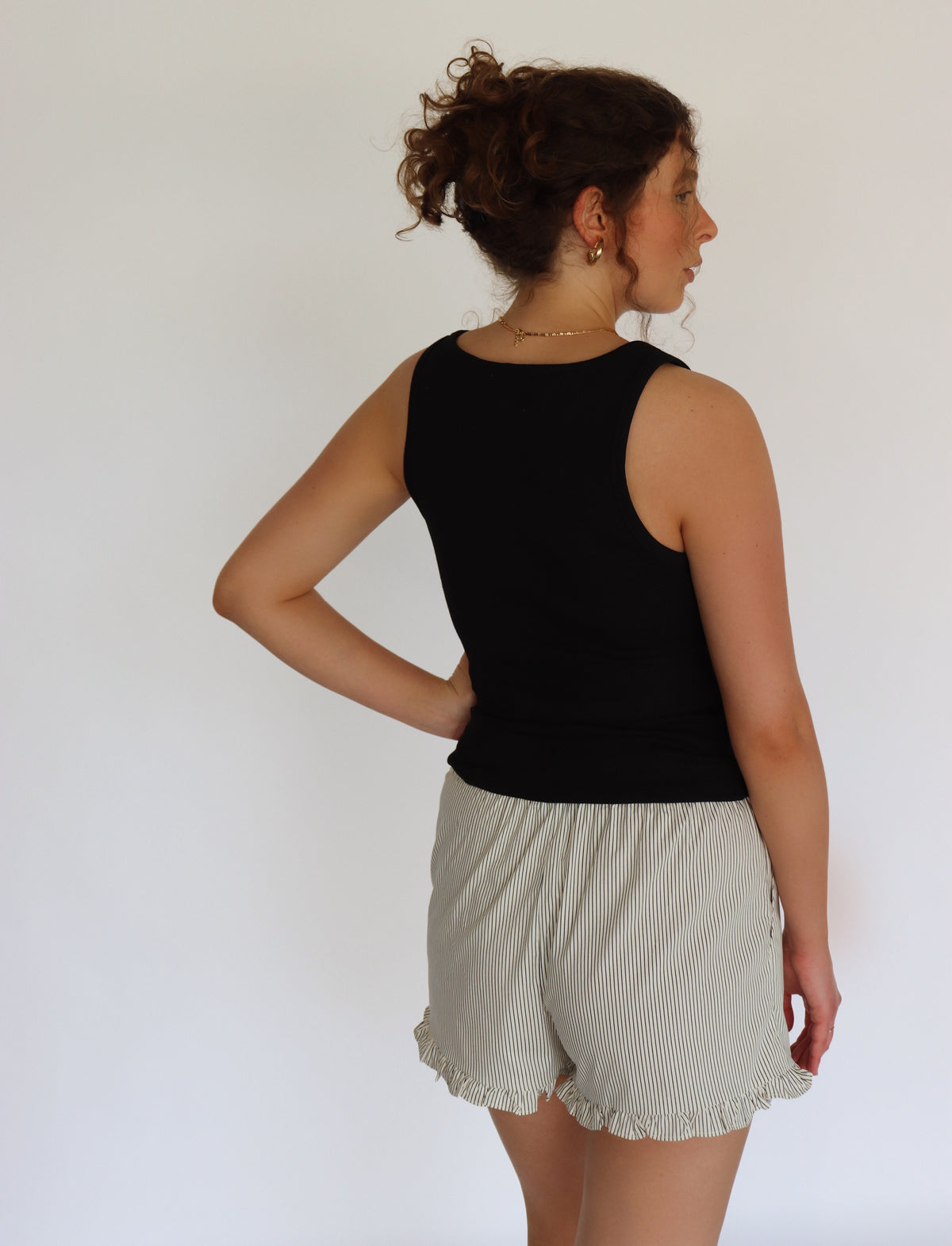 woman wearing a black tank top and striped shorts