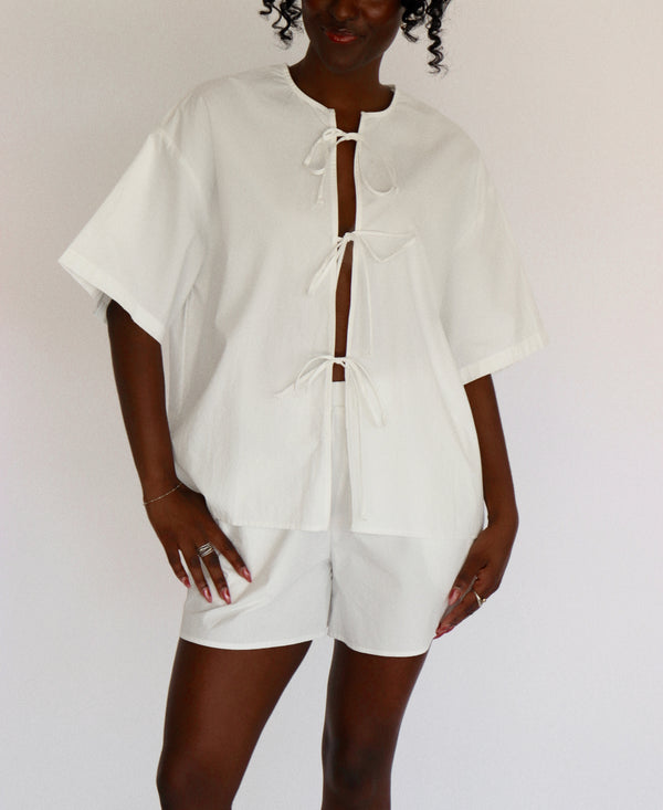 Person wearing a white outfit set with a plain background