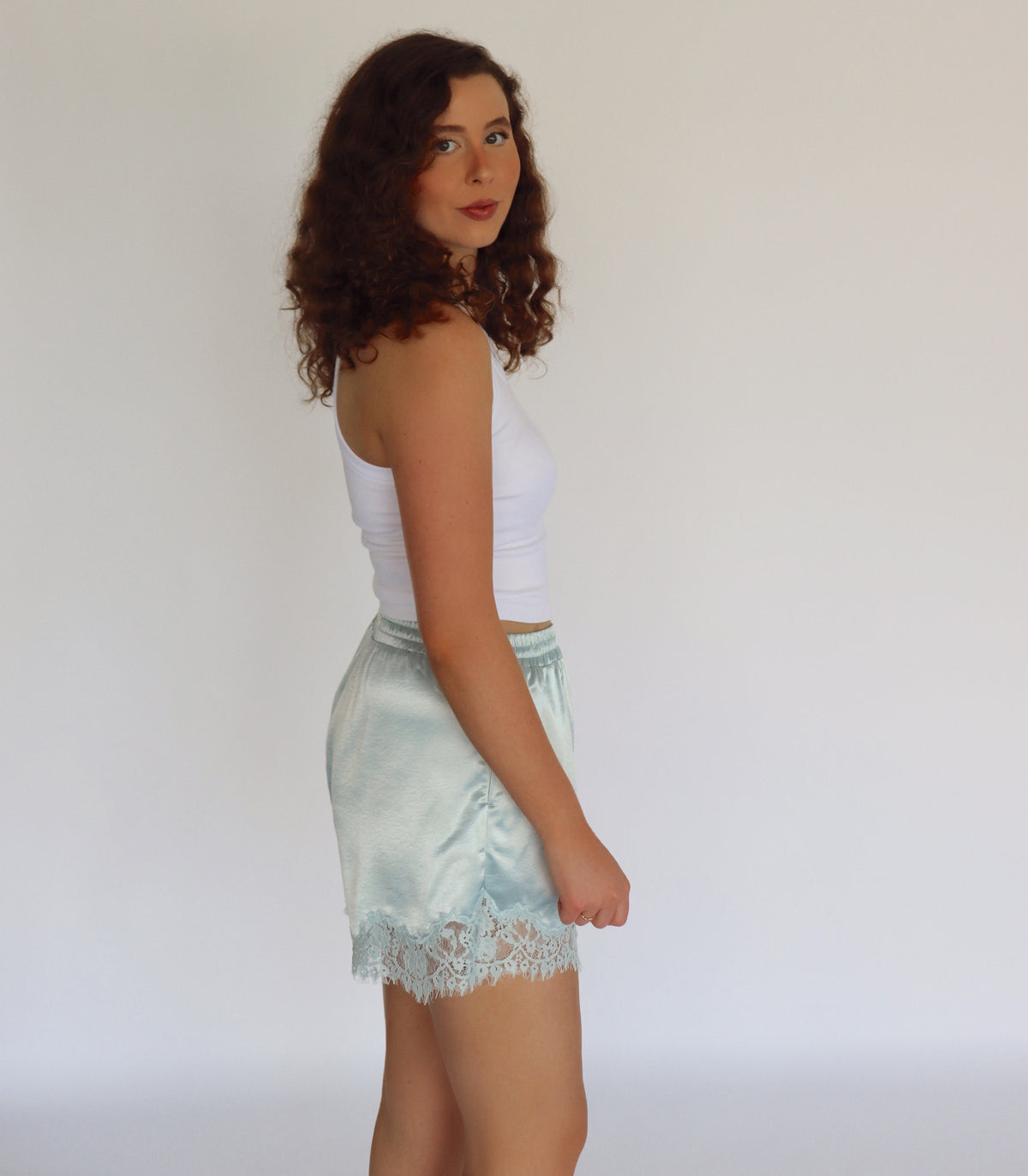 woman wearing mint blue colored shorts and a white tank top