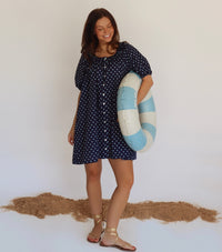 Woman in a navy dress with blue polka dots 