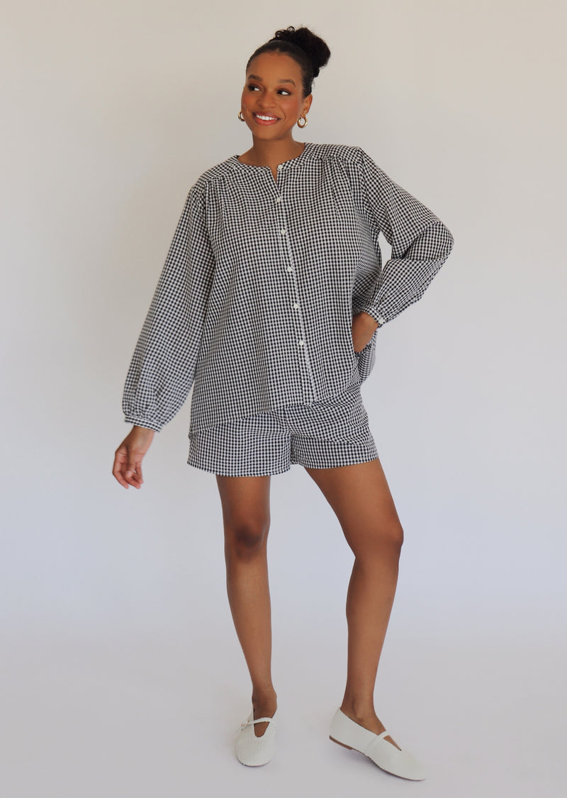 Person wearing a black and white checkered outfit on a plain background