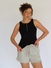 woman wearing a black tank top and striped shorts