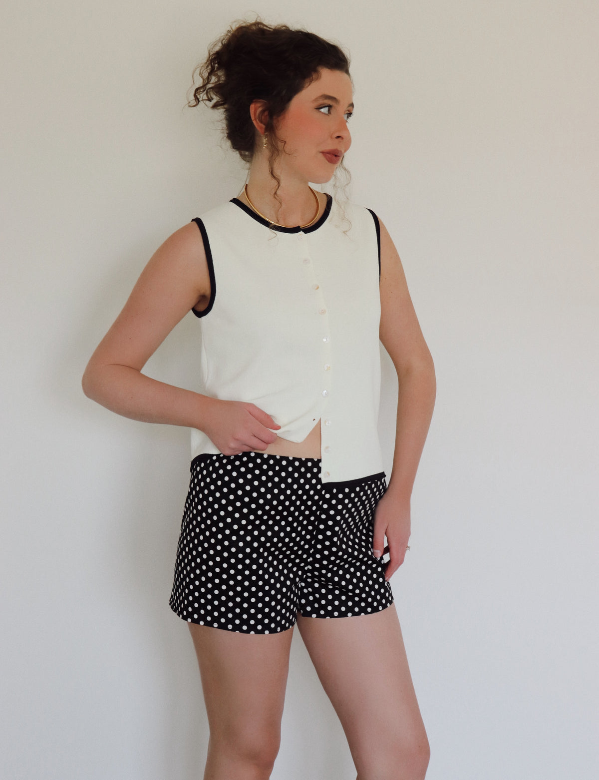 Woman in a white top with black polka dot shorts