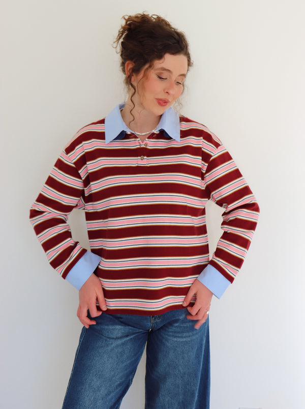 Person wearing a striped shirt with a plain background