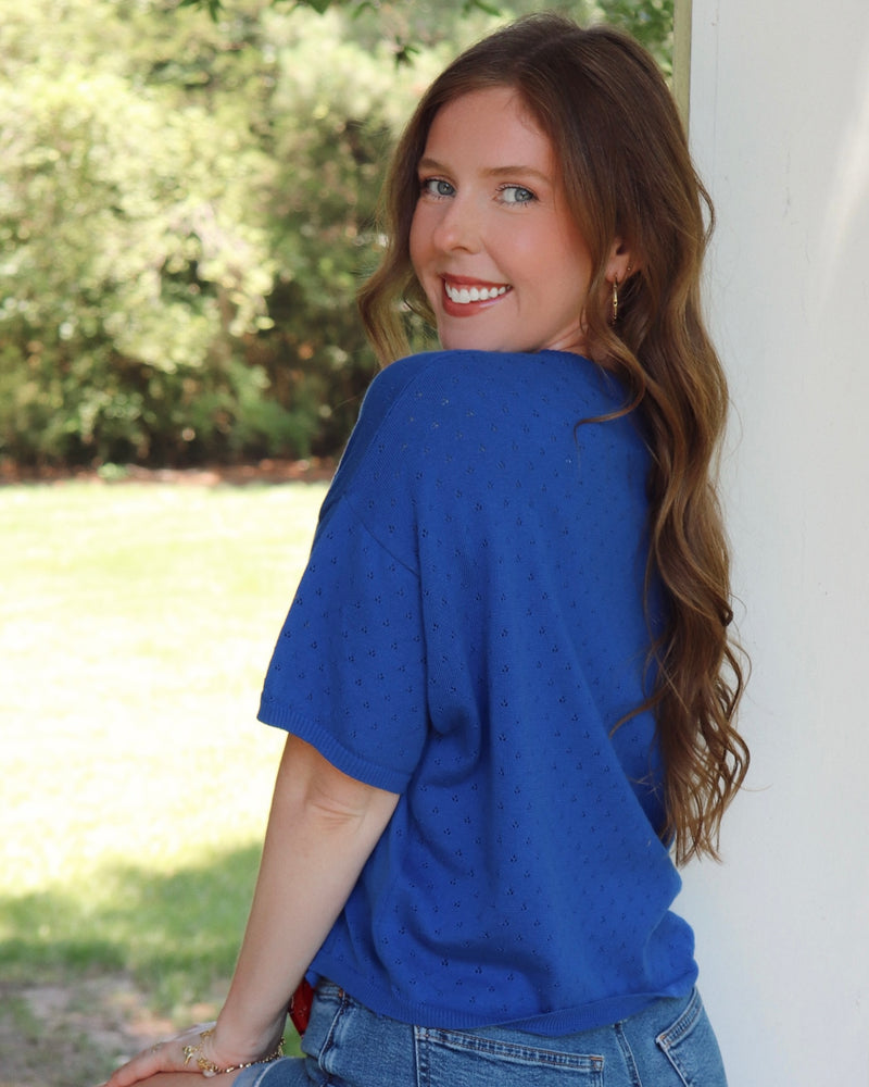 Woman in blue cardigan in an outside setting