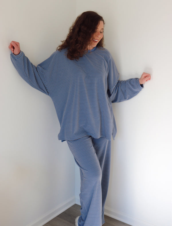 Woman wearing a blue set against a white wall