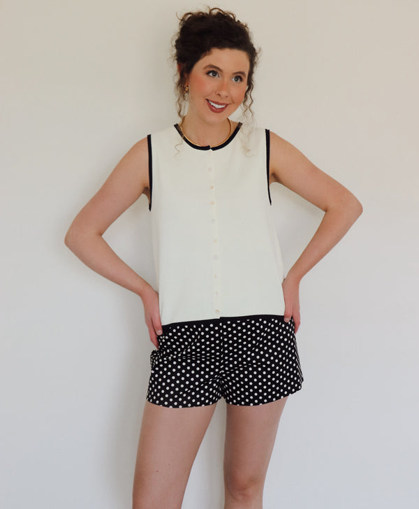 Woman in a white top with black polka dot shorts