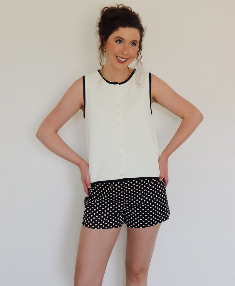 Woman in a white top with black polka dot shorts
